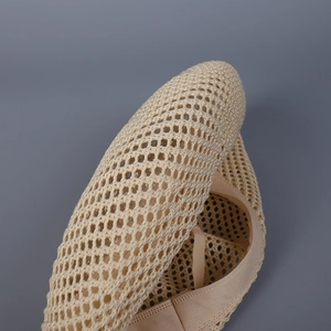 Detailed macro view of beige mesh fabric texture with breathable hollow structure design