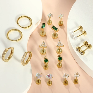 Detailed set of golden earrings with emerald green stones and white zircons