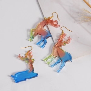 Detailed macro of elk unicorn resin earrings with colorful gradient and gold glitter finish