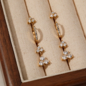 Four sets of dainty gold clover studs and zircon hoop earrings in a velvet jewelry box