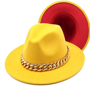 Detail of yellow fedora with gold chain featuring red and yellow contrast interior design