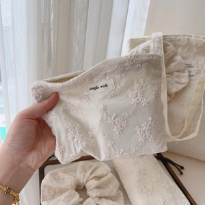Detailed shot of cotton tote bags with delicate floral embroidery and lace accents