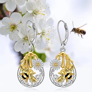 Detalle de pendientes de cierre catalán con motivos de abeja y margarita bicolor