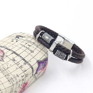 Detail of dark brown braided leather bracelet with magnetic clasp on vintage map case