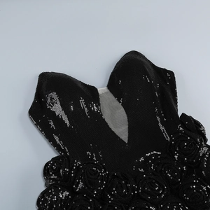 Detail of V-neckline featuring black sequins and handcrafted 3D floral accents on evening dress