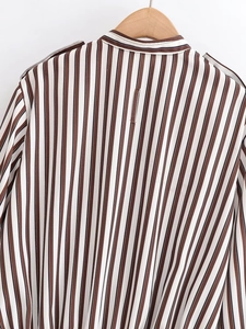 Dettaglio posteriore della camicia a maniche lunghe a righe marroni e bianche su gruccia