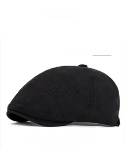 Detail view of the black six-panel newsboy cap showing textured fabric and stitching