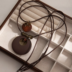 Bohemian double-layer necklace with brown wood circles and bow pendant in a jewelry box