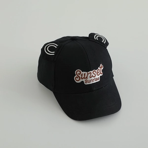 Detail of a black cotton kids baseball cap featuring 3D ears and sunset embroidery
