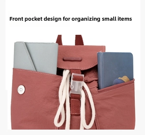 Detail of rust red nylon backpack front pockets holding a wallet and notebook