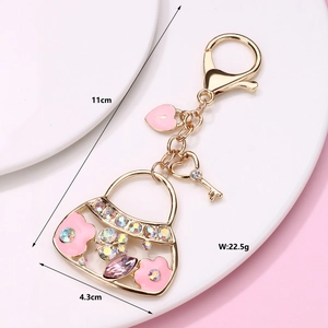Pink handbag keychain with golden enamel and colorful crystals detail showing dimensions