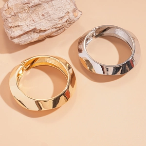 Chic twisted metal bangle bracelets in gold and silver finish with minimalist geometry