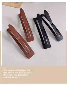 Détail de pinces à cheveux mates marron et noir avec un design minimaliste élégant