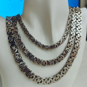 Detail view of various thickness silver Byzantine chain necklaces for men on a mannequin