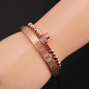 Détail du jonc à chiffres romains or rose et bracelet à perles couronne au poignet