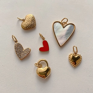 Detail showing heart charms in gold, red enamel, pearl shell and zircon finishes