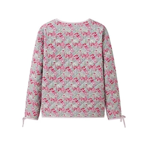 Rear view of pink floral quilted jacket featuring lace-up bow details on the long sleeves