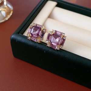 Macro detail of square purple crystal earrings with diamond halo in a jewelry box