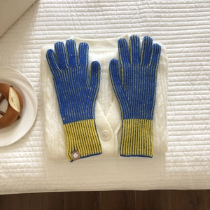 Primer plano de guantes de punto a rayas azul y amarillo con etiqueta de cuero