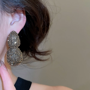 Macro shot of double-layer teardrop earrings with pavé crystals and vintage finish