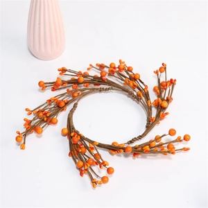 Detail showing orange artificial berry wreath with rustic brown twigs on white background