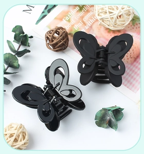 Detail of glossy and matte black butterfly hair claws with elegant hollow wings