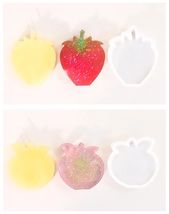 Detail showing strawberry and apple silicone molds with finished wax candles and resin casts