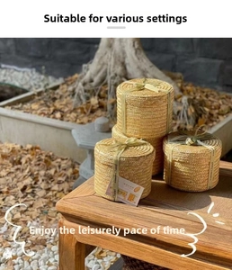 Macro shot of three-piece round woven gift boxes with ribbon on a zen garden table