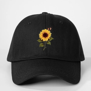Detail of sunflower and butterfly print on black baseball cap with curved brim