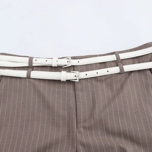 Detail of a brown pinstripe trouser waist featuring a unique double white leather belt
