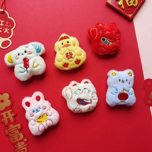 Detailed plush animal brooches with Chinese festive embroidery like koi fish and fortune symbols