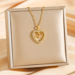 Elegant gold titanium heart pendant necklace with zircons on a luxury silk background