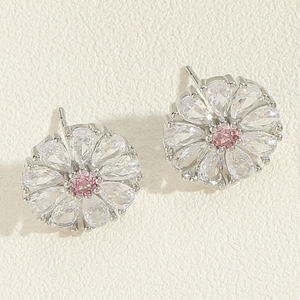 Macro detail of daisy floral stud earrings featuring pink gem and pear-cut clear petals