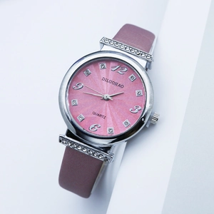 Close-up of pink sunray dial quartz watch with crystal indices and brown leather strap