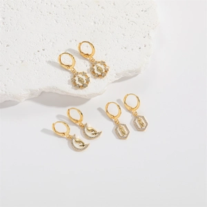 Three pairs of bohemian gold dangling earrings featuring religious icons and white zircons