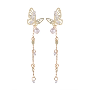 Detail of butterfly drop earrings with zircon, pearls and long tassels in gold