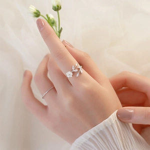Detail of S925 silver open ring featuring white shell flower and leaf-cut zircons