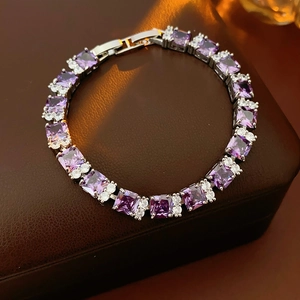 Primer plano de pulsera plateada con circonitas púrpuras de corte cuadrado sobre fondo oscuro