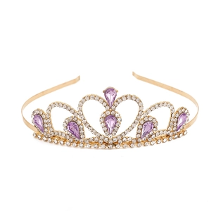 Golden princess tiara with purple teardrop crystals and rhinestones on a white backdrop