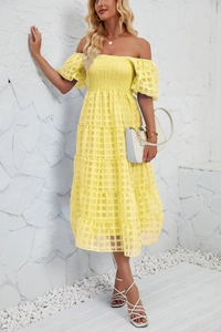 Detailed view of yellow off-shoulder dress with puff sleeves and textured checkered fabric