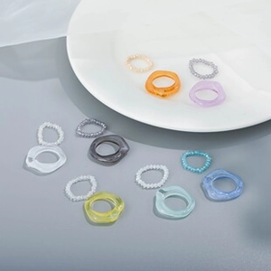 Vibrant acrylic resin rings and beaded jewelry set in orange, purple, and blue tones