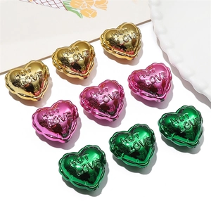 Close-up of heart-shaped acrylic beads in gold, pink and green with Hot Love engraving