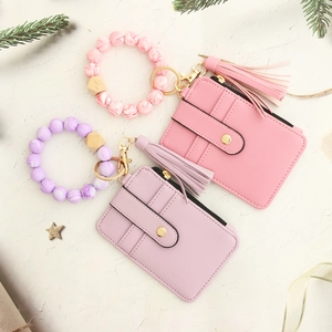 Detail of pink and purple pebble leather card wallets with beaded wristlets and tassels