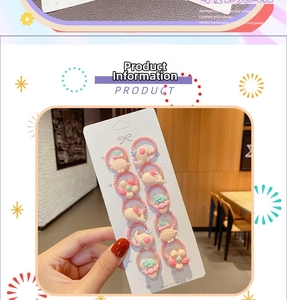 Detailed view of children's pink elastic hair ties with cute cartoon animal and fruit charms