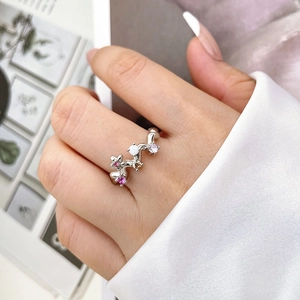 Détail macro d'une bague branche en argent avec zircons colorés portée par un mannequin