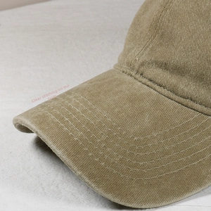 Detailed close-up of parallel stitching on khaki corduroy baseball cap visor