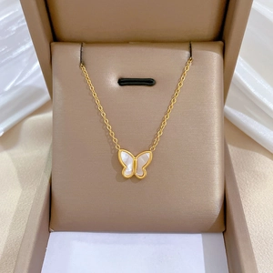 Detailed view of a gold titanium steel butterfly necklace nestled in a luxury jewelry box