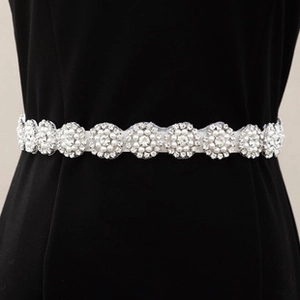 Close-up of bridal belt with sparkling rhinestones and pearls on a silver metal base