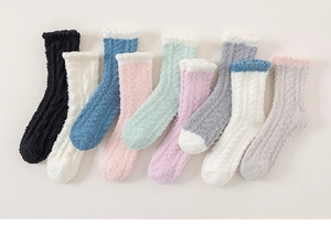 Detailed close-up of colorful coral fleece socks with elegant lace trim and soft texture