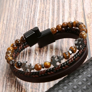 Detail view of multi-layer men's leather bracelet with tiger eye beads and anchor charm